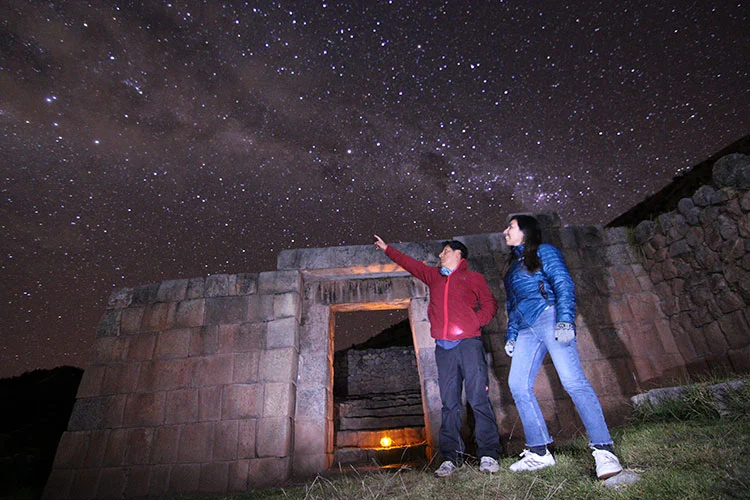 Visitors learning about Inca astronomy at the Cusco Planetarium near Sacsayhuamán, Peru, under the Andean night sky and Milky Way.
