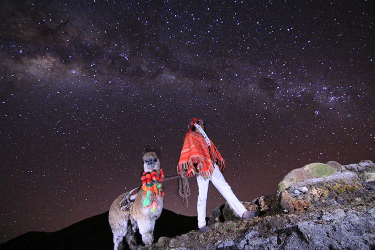 Stargazing on the Lares Trek in Peru beneath the Milky Way, surrounded by Andean mountains and traditional Quechua communities.