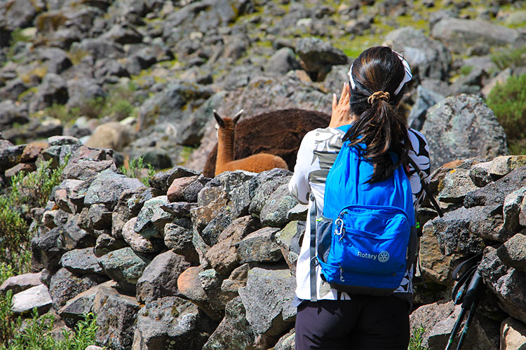 Solo traveler learning traditional Andean weaving from Quechua artisans in the Sacred Valley, Peru.