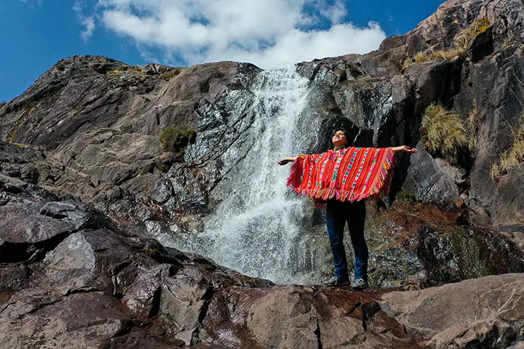 Solo traveler exploring a remote Andean village in Peru, surrounded by mountains and experiencing authentic Quechua culture beyond the famous tourist destinations.
