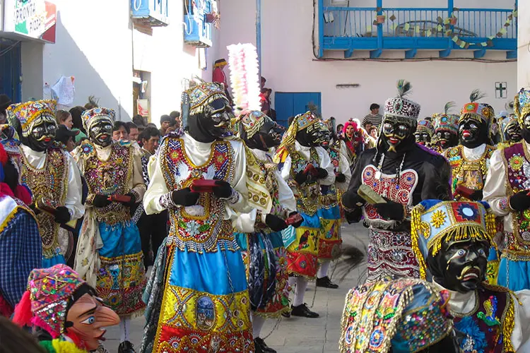 Traditional dancers celebrating the Paucartambo Festival in Cusco, Peru, honoring the Virgen del Carmen through colorful costumes, music, and Andean traditions.